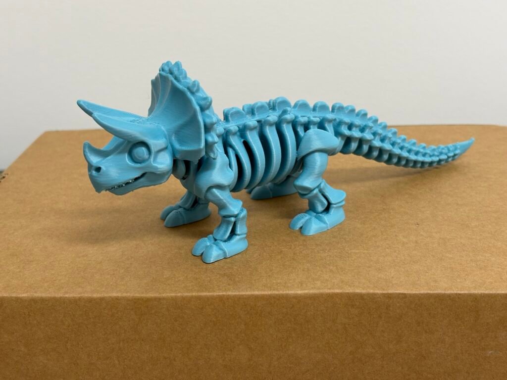 Esqueleto de Triceratops impresso em 3D em filamento PLA azul.